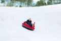 Happy teenage girl sliding down on snow tube Royalty Free Stock Photo