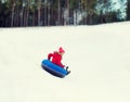 Happy teenage girl sliding down on snow tube Royalty Free Stock Photo