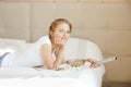 Happy teenage girl with TV remote and popcorn Royalty Free Stock Photo