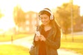 Happy teen in a park listening to music at sunset Royalty Free Stock Photo