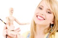 Happy teenage girl with wooden model dummy Royalty Free Stock Photo