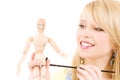 Happy teenage girl with wooden model dummy Royalty Free Stock Photo