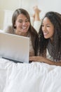 Happy Teenage Girls Using Laptop In Bed Royalty Free Stock Photo