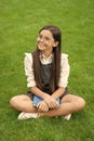 Happy teenage school girl sitting legs crossed on grass. School and education. Back to school Royalty Free Stock Photo