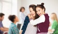 Happy teenage student girls hugging at school Royalty Free Stock Photo