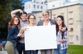 Happy teenage students holding white blank board Royalty Free Stock Photo