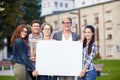 Happy teenage students holding white blank board Royalty Free Stock Photo