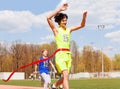 Happy teenage winner crossing the finish line Royalty Free Stock Photo