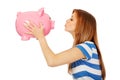 Happy teenage woman kissing a piggybank Royalty Free Stock Photo