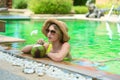 Teenage happy young girl enjoy her trip on vacation on tropical island in swimming pool with coconut juice Royalty Free Stock Photo