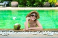 Teenage happy young girl enjoy her trip on vacation on tropical island in swimming pool with coconut juice Royalty Free Stock Photo