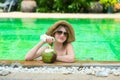 Teenage happy young girl enjoy her trip on vacation on tropical island in swimming pool with coconut juice Royalty Free Stock Photo