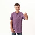 Happy teenaged disabled boy with cerebral palsy smiling and showing thumbs up at camera, posing isolated over white Royalty Free Stock Photo