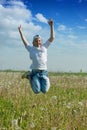 Happy teenager boy jumps at meadow Royalty Free Stock Photo