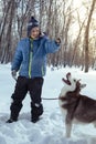 Happy teenager boy playing with white Husky dog in winter day, dog and child on snow Royalty Free Stock Photo