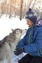 Happy teenager boy playing with white Husky dog in winter day, pet and child game on snow Royalty Free Stock Photo