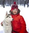 Happy teenager boy playing with white Husky dog in winter day, pet and child on snow Royalty Free Stock Photo