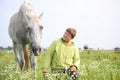 Happy teenager boy and white horse at the field Royalty Free Stock Photo