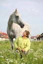 Happy teenager boy and white horse at the field Royalty Free Stock Photo