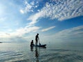 Happy teenager children in swimsuits  having fun on SUP board and  paddling in sea Royalty Free Stock Photo