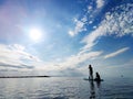 Happy teenager children in swimsuits  having fun on SUP board and  paddling in sea Royalty Free Stock Photo