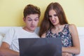 Happy teenager girl and boy watching a laptop Royalty Free Stock Photo