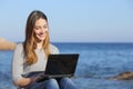 Happy teenager girl browsing social media on the beach