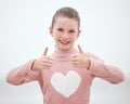 Happy, teenager girl and hands in thumbs up with smile for gesture, sign or symbol against a grey background. Portrait Royalty Free Stock Photo