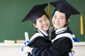 Happy teenager in graduation gowns hugging and smiling