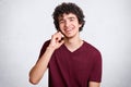 Happy teenager or hipster guy, speaks via cell phone with best friend, has delighted expression, recieves good news, smiles gently Royalty Free Stock Photo