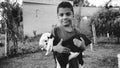 Happy teenager Indian boy holding little black and white baby goat in the meadow Royalty Free Stock Photo