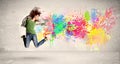 Happy teenager jumping with colorful ink splatter on urban background Royalty Free Stock Photo