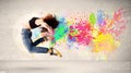 Happy teenager jumping with colorful ink splatter on urban backg Royalty Free Stock Photo