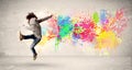 Happy teenager jumping with colorful ink splatter on urban background Royalty Free Stock Photo