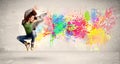 Happy teenager jumping with colorful ink splatter on urban background Royalty Free Stock Photo