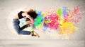 Happy teenager jumping with colorful ink splatter on urban backg Royalty Free Stock Photo