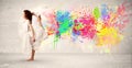 Happy teenager jumping with colorful ink splatter on urban background Royalty Free Stock Photo