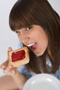 Happy teenager in pajamas eating healthy toast