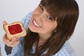 Happy teenager in pajamas eating healthy toast