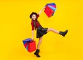 Happy teenager portrait. Beautiful fashion teenager child girl with shopping bags on yellow background. Shopaholic Royalty Free Stock Photo