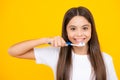 Happy teenager portrait. Teenager girl brushing her teeth over isolated yellow background. Daily hygiene teen child hold Royalty Free Stock Photo