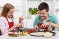 Happy teenagers having fun in the kitchen preparing a pizza Royalty Free Stock Photo