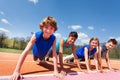 Happy teenagers holding plank outdoor on the track