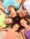 Happy teenagers lying on a sandy beach