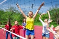 Happy teenagers playing near the volleyball net Royalty Free Stock Photo