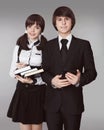 Happy teenagers in school uniform portrait. Handsome boy and beautiful brunette girl posing isolated on studio background. Royalty Free Stock Photo