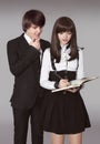 Happy teenagers in school uniform portrait. Handsome boy and beautiful brunette girl posing isolated on studio background. Royalty Free Stock Photo