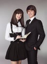 Happy teenagers in school uniform portrait. Handsome boy and beautiful brunette girl posing isolated on studio background. Royalty Free Stock Photo