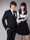 Happy teenagers in school uniform portrait. Handsome boy and beautiful brunette girl posing isolated on studio background. Royalty Free Stock Photo