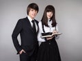 Happy teenagers in school uniform portrait. Handsome boy and beautiful brunette girl posing isolated on studio background. Royalty Free Stock Photo